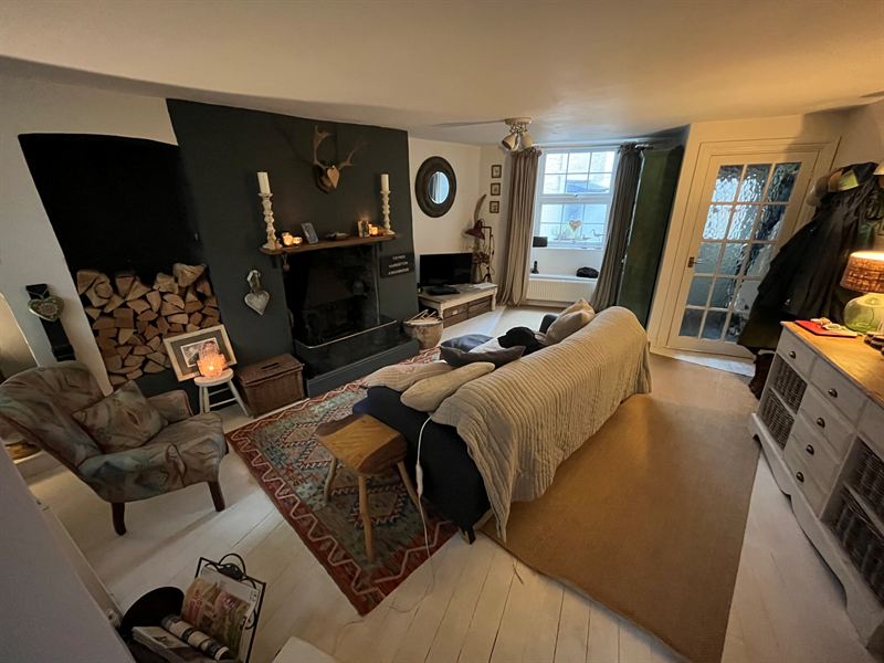 Lounge with a dark painted fireplace wall and wood burner