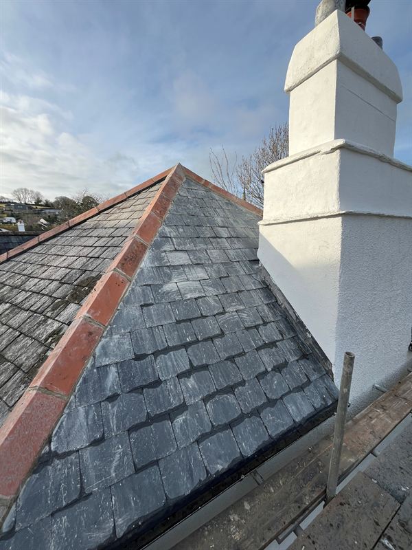 Freshly painted white chimney against a slate roof
