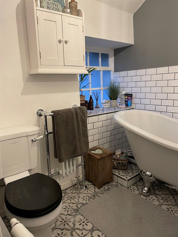 Bathroom with a roll-top bath and white metro tiles